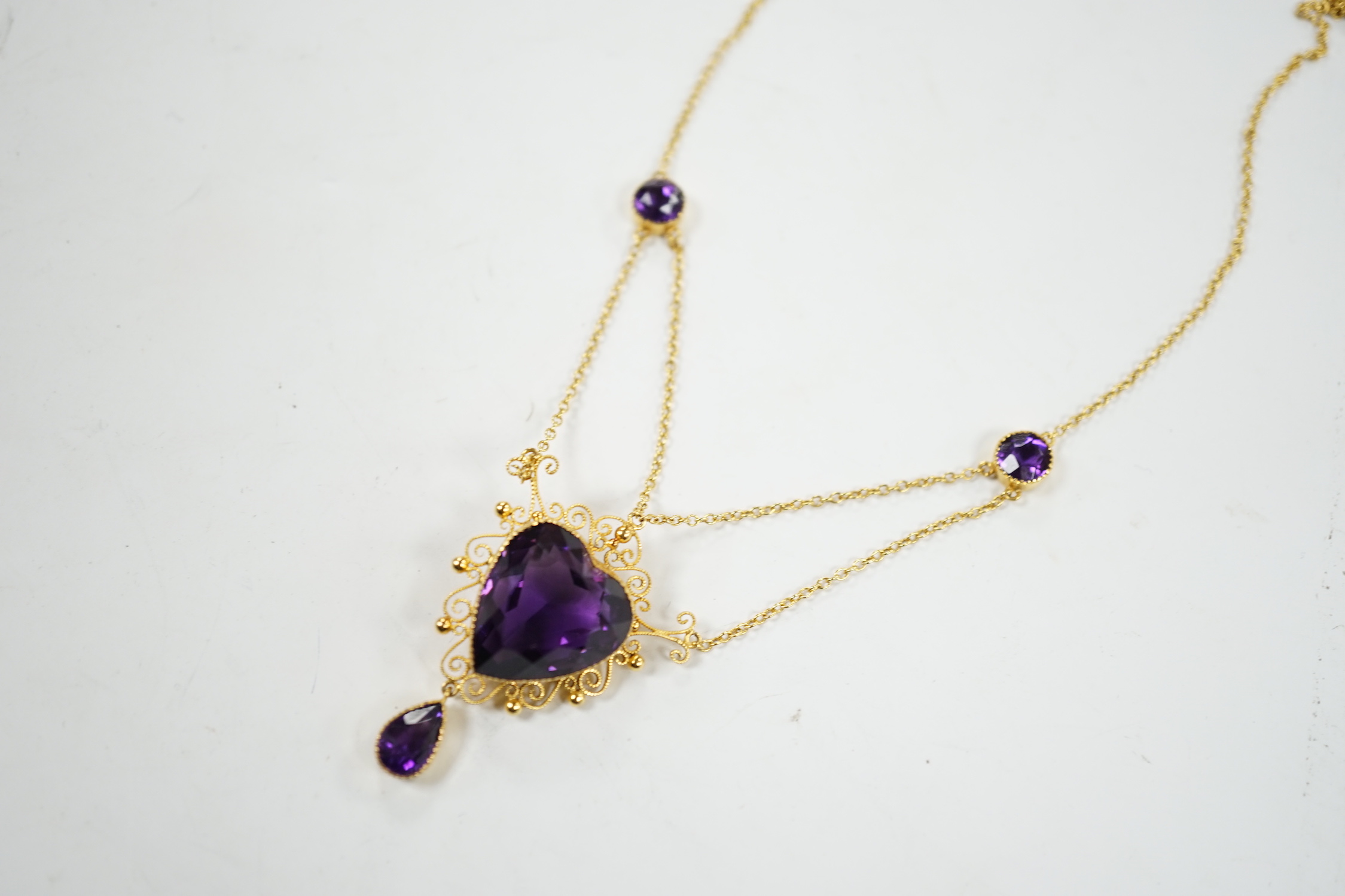 A Victorian style 9ct and four stone amethyst drop pendant necklace, the pendant set with heart shaped central stone and pear cut drop, overall 46cm, gross weight 8 grams.